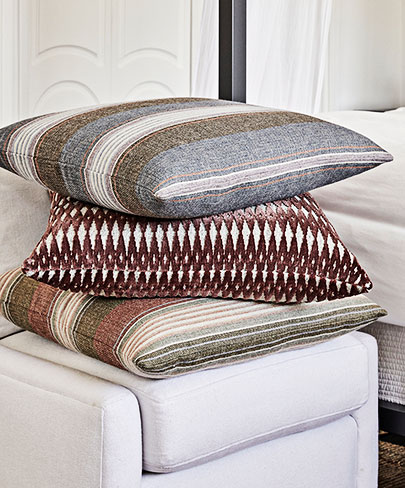 Three pillows stacked on an ottoman